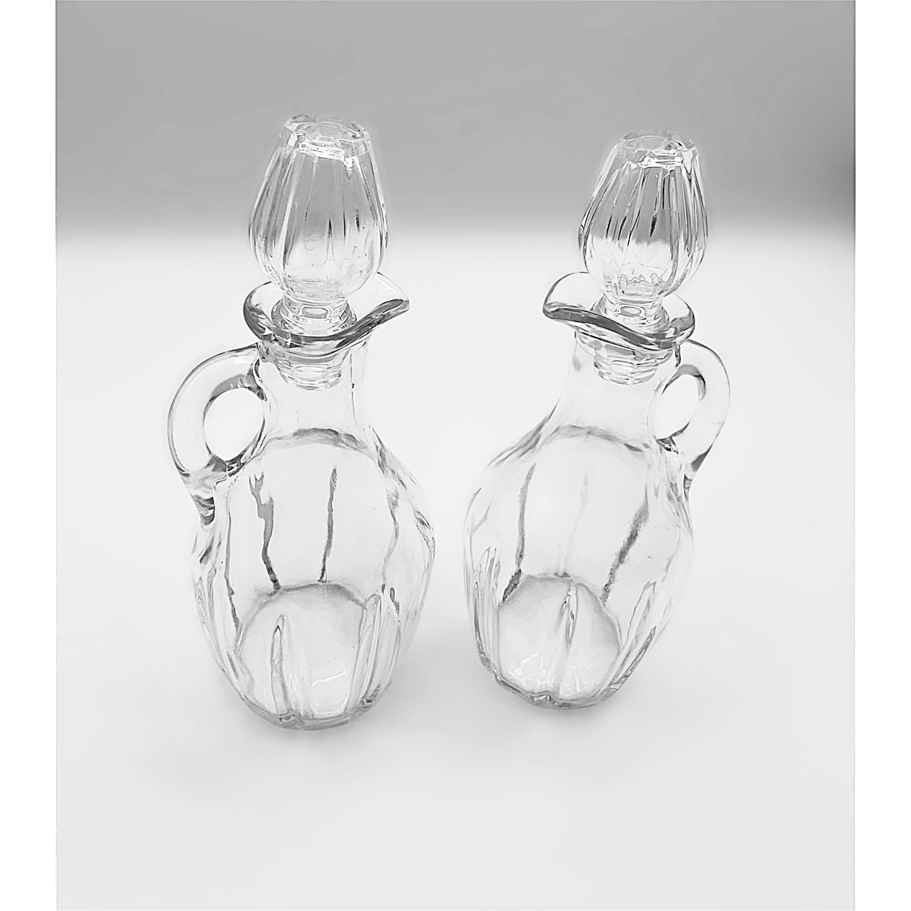 Ampolle con manico e tappo in vetro trasparente set of two clear glass bottles with handles and stoppers for oil and vinegar.