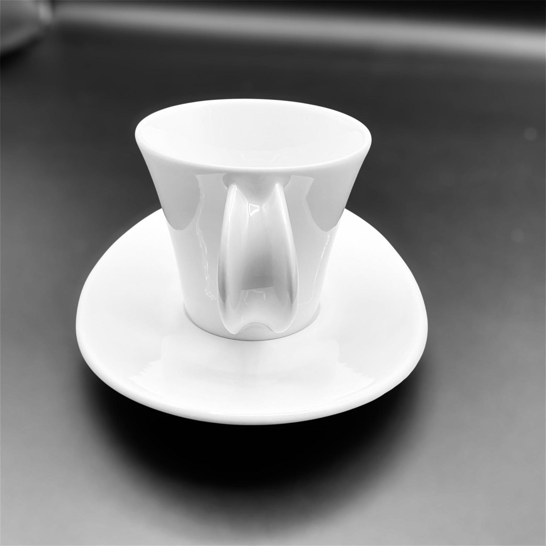Set 6 tazze caffè Funé by Giugiaro porcellana Ginori white porcelain cup with oval saucer on black surface.