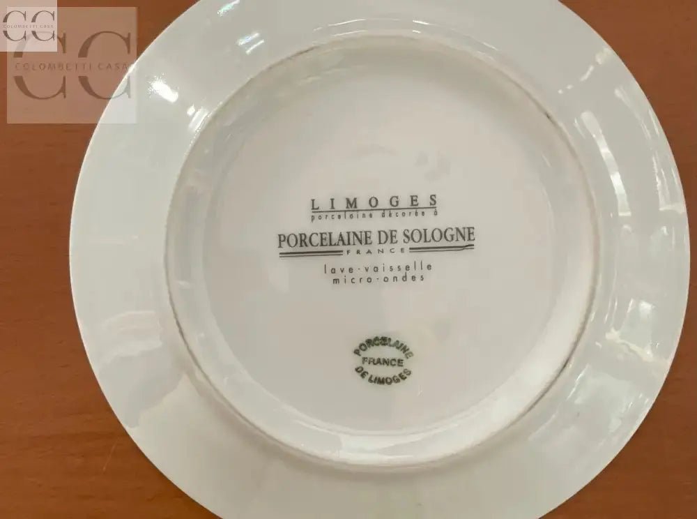 Piatto in porcellana Limoges presentato con set di tazzine da caffè